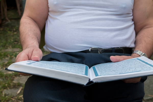 Man met Koran op de schoot